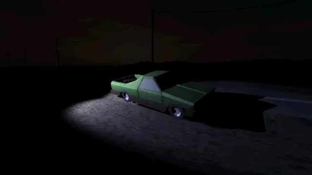 A green car lit by a single streetlight on an empty road at night