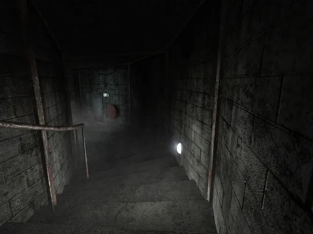 Penumbra: Overture screenshot: a dim concrete stairwell with a rusty handrail leading down to a misty landing lit by a single wall lamp