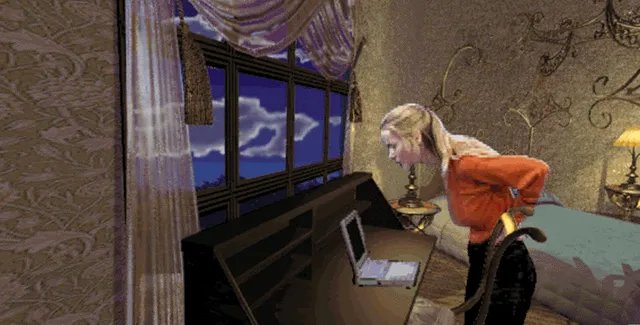 Adrienne bends over a laptop on a desk in an ornate bedroom at night