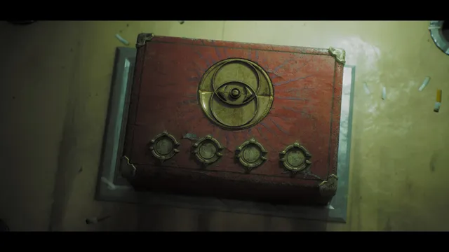 A red puzzle box with an eye emblem and four dials on a dirty floor