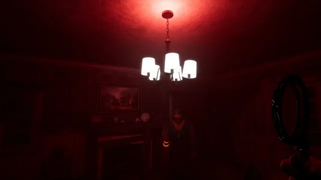 A living room bathed in red light under a chandelier, a figure half hidden in the shadows