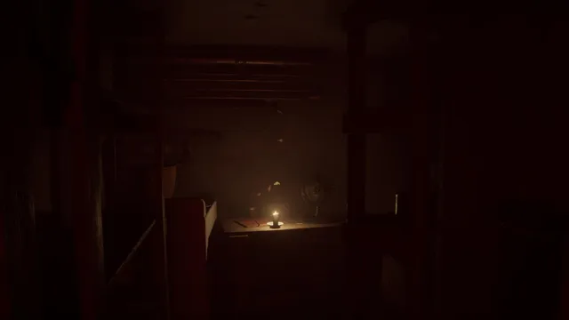A single candle burns on a table in a dark, cluttered room of the apartment