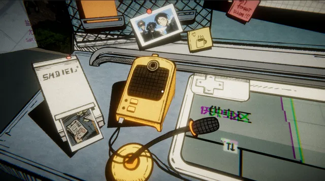 The desk seen from above: a yellow radio, a photo receiver, a monitor with a glitching image and sticky notes