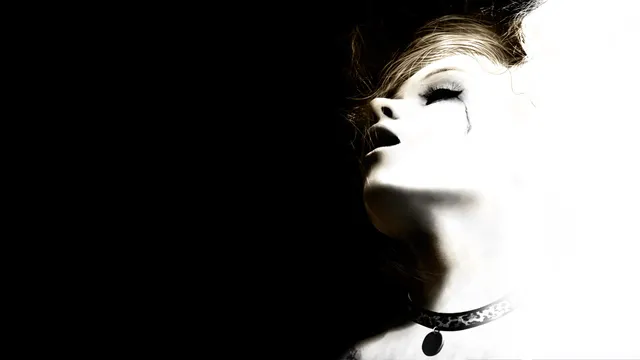 Silent Hill: HD Collection art: a pale woman's face tilted back in the dark, a choker at her neck