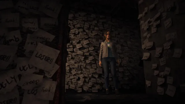 Anita standing in a narrow room whose walls are covered with paper notes reading LOSER and UGLY