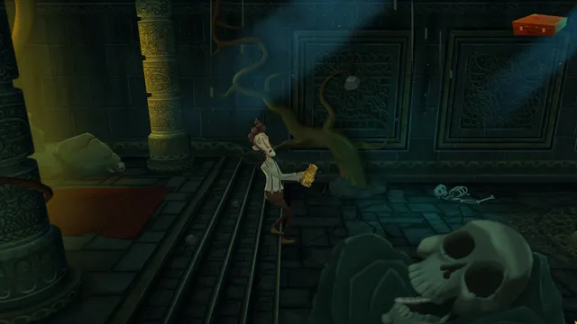 Harvey holds up a small object on the steps of a dim crypt with a giant skull and scattered bones