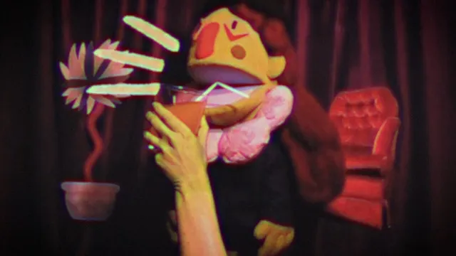 Smile For Me screenshot: a live-action puppet with a big nose sips a drink through a straw beside a flower and a red armchair