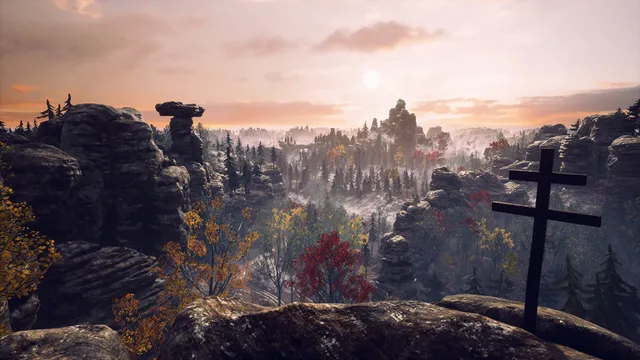 A view over sandstone rocks and autumn forest at sunset, a wooden cross on the cliff edge