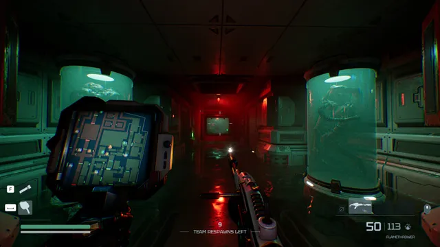 A green and red lab corridor lined with specimen tanks, seen past a handheld mini-map and a flamethrower