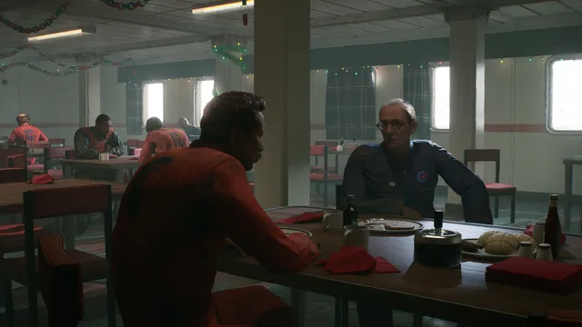 Still Wakes the Deep screenshot: two rig workers talking across a table in the canteen, decorated with tinsel