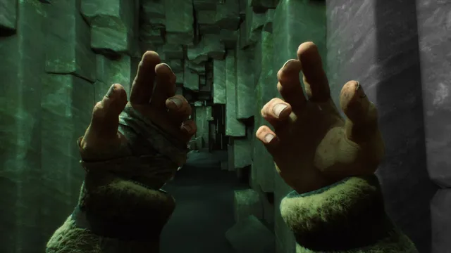The player's hands raised in a narrow corridor of green, alien stone