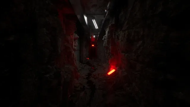 A dark tunnel of rough rock walls lit by a single red flare
