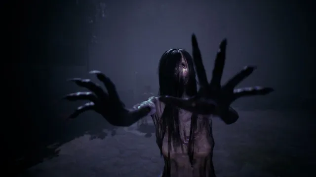 The long-haired female ghost reaches toward the player with blackened, clawed hands