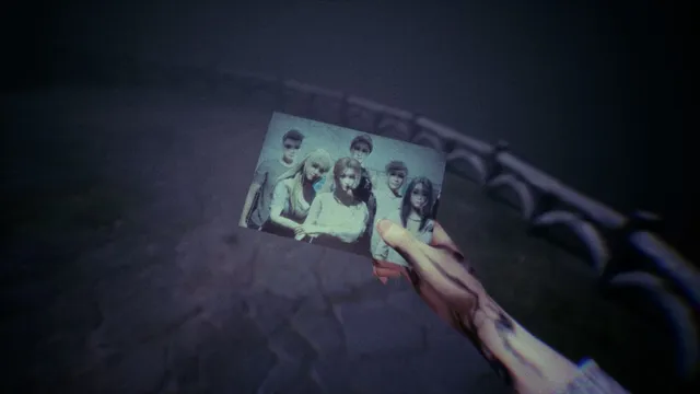 A hand holds up a photo of the students on the bridge at night