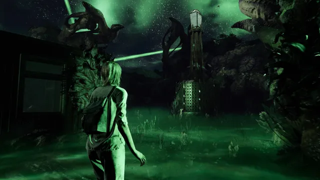 Jess walks through green-lit, overgrown ground toward a lantern tower under strange stone shapes