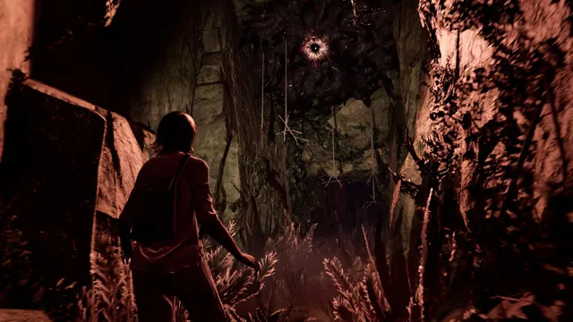 Jess in a rocky ravine looking up at a huge eye surrounded by dark tendrils