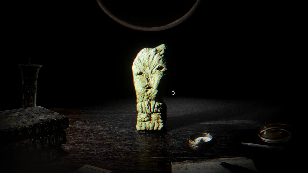 The Children of Clay screenshot: a pale clay figure with a carved face stands lit on a dark desk beside old books and a compass