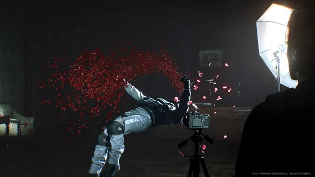 The Evil Within 2 screenshot: a victim frozen mid-air in a spray of blood before a camera on a tripod