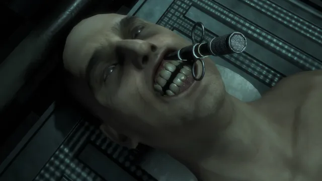 The Mortuary Assistant screenshot: a corpse on the embalming table with a metal instrument held in its grinning mouth