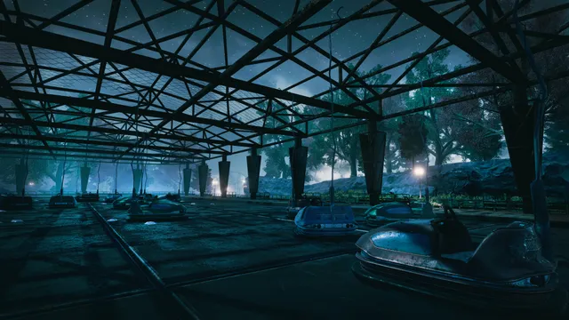 Empty bumper cars under a steel roof frame at night