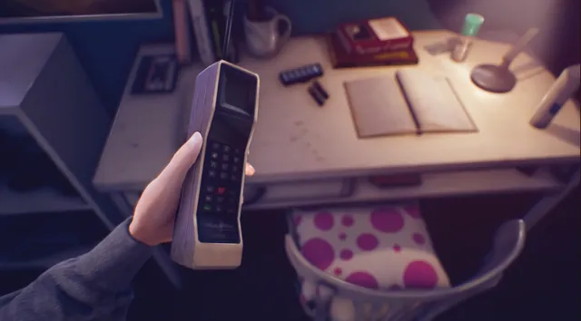 Nicole's hand holds a brick-sized early mobile phone beside a desk with an open notebook and a lamp