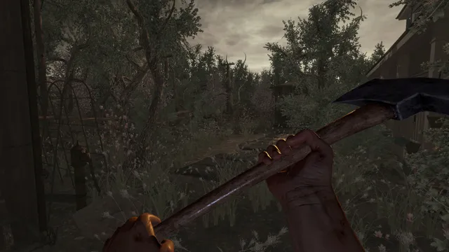First-person view gripping an axe in the overgrown backyard of the homestead under a grey sky