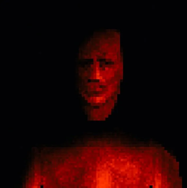 A face lit red, staring out of the darkness