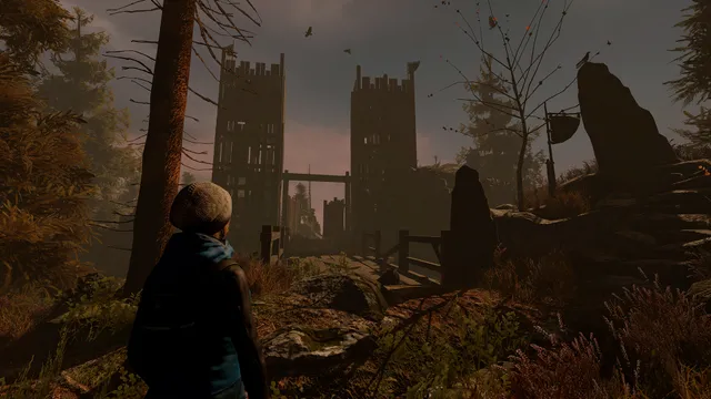 A child in a wool hat looks up at two tall wooden watchtowers at dusk