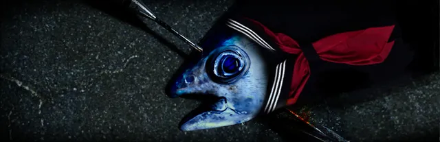 UMIGARI key art: a fish's head in a sailor school uniform collar, pinned by a harpoon on dark ground