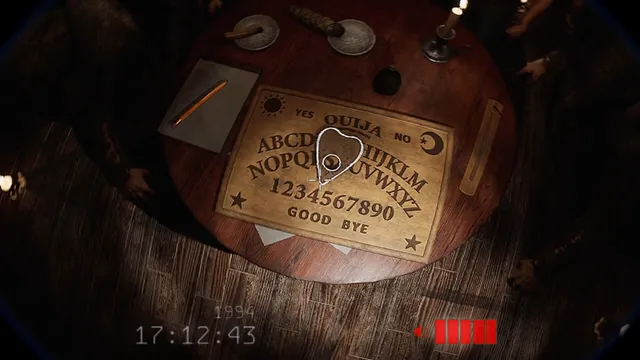 The planchette moving across a Ouija board on a round wooden table