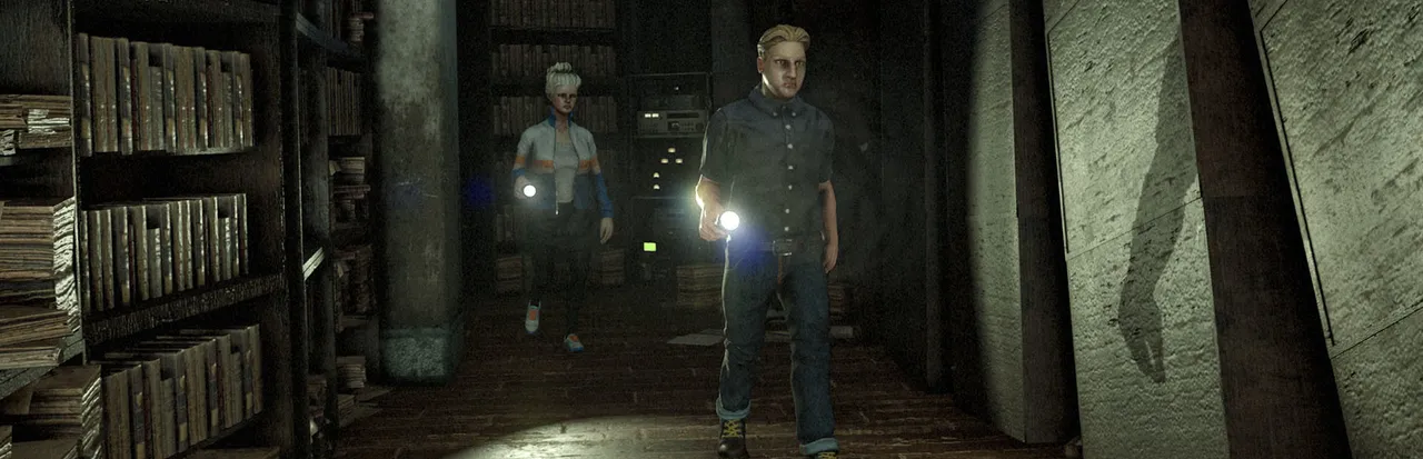 Two White Noise 2 investigators walk with flashlights between tall shelves of books in a dark archive