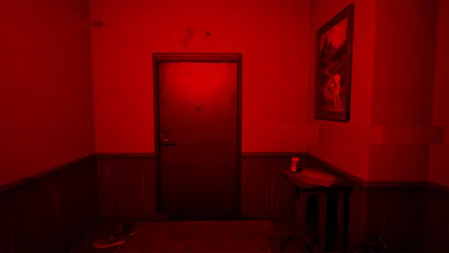 A room drenched in red light, with a closed door and a painting on the wall