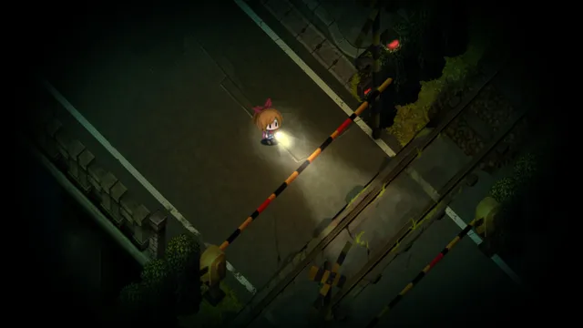 Seen from above, a girl shines her flashlight near a railway crossing on a dark street